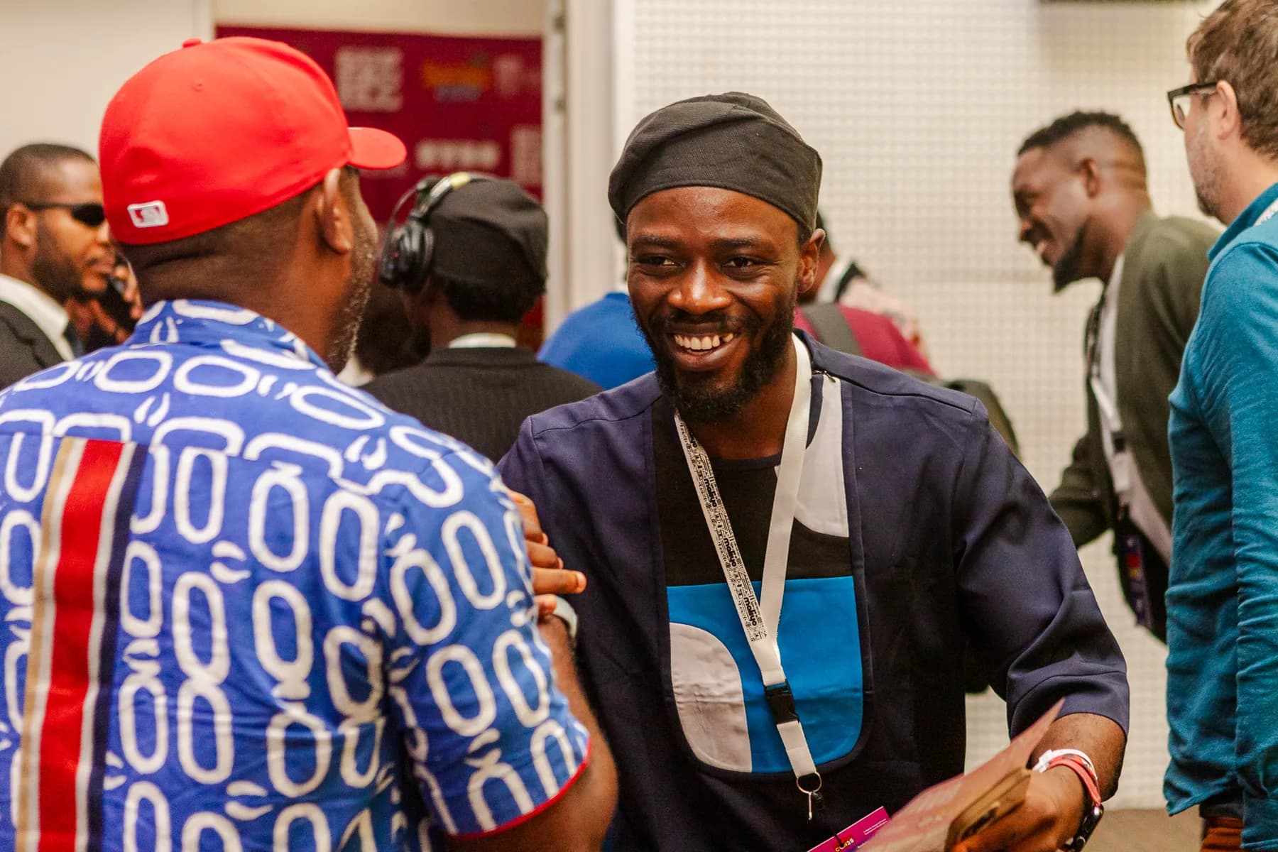Two men greeting each other warmly in a crowded networking area